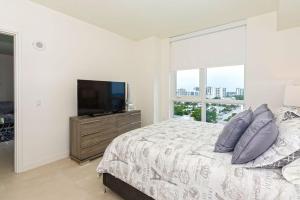 a bedroom with a bed and a flat screen tv at Departamento en Tiffany House Fort Lauderdale beach Miami in Fort Lauderdale +30 photos