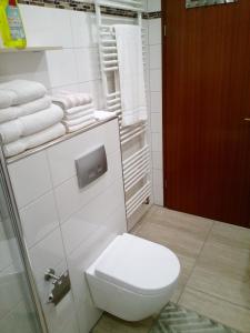 a white bathroom with a toilet and towels at Appartement Willmeroth in Königswinter