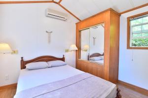 a bedroom with a bed and a large mirror at PANORAMA Ocean View Cottage in Motobu