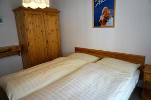 een slaapkamer met een bed en een schilderij aan de muur bij Paradies 026 in Arosa +16 foto's