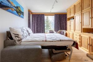 Schlafzimmer mit einem Bett und einem Fenster in der Unterkunft Casa Viktoria B26 in Arosa