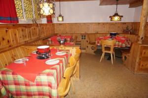 een eetkamer met twee tafels met rode en groene tafelkleden bij Paradies 001 in Arosa