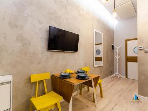 コウォブジェクにある3L Apartments Exclusiveのダイニングルーム(テーブル、黄色い椅子付)