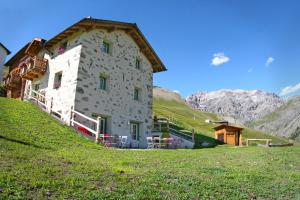 a building on a hill with mountains in the background at Al Solìf in Livigno