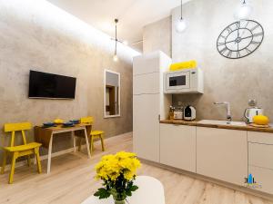 コウォブジェクにある3L Apartments Exclusiveのキッチン(電子レンジ、テーブル、黄色い椅子付)