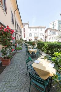 - une rangée de tables et de chaises sur la terrasse dans l'établissement Antica Trattoria dell'Uva, à Monza