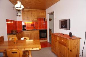 een keuken met houten kasten en een houten tafel bij Paradies 026 in Arosa
