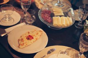 einen Tisch mit einem Teller Pizza und einer Schüssel Käse in der Unterkunft Vila Alba in Fortim