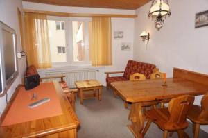 een woonkamer met een houten tafel en een bank bij Paradies 026 in Arosa