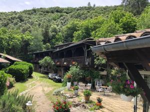 ein Haus mit einem Balkon und einem Hof mit Pflanzen in der Unterkunft Le Sentier des Arches in Beaumont