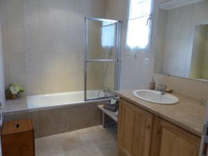 a bathroom with a tub and a sink and a shower at Les Amandines in Chisseaux