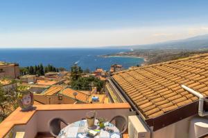 a table on a balcony with a view of the ocean at Amart&igrave;a Apartments in Taormina
