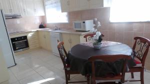 a kitchen with a table and chairs and a microwave at The Garden House in Tamworth +7 photos