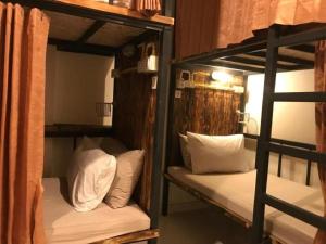 two bunk beds with white pillows in a room at B&B hostel @ Jomtien in Jomtien Beach +45 photos