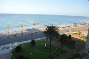 een uitzicht op een strand met palmbomen en de oceaan bij Argentino Hotel Casino & Resort in Piriápolis