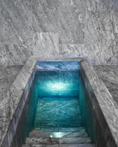 a pool of blue water in a stone wall at Nobis Hotel Copenhagen, a Member of Design Hotels™ in Copenhagen