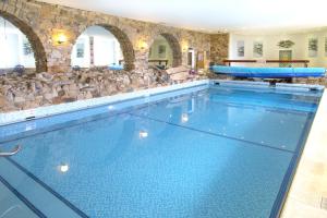 a swimming pool with a blue tub and blue chairs at Sands Resort Hotel in Newquay
