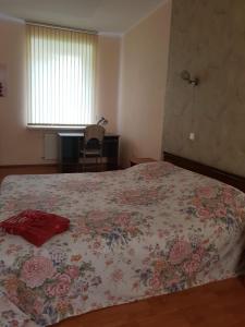 - une chambre dotée d'un lit avec un couvre-lit floral dans l'établissement Saule, à Daugavpils