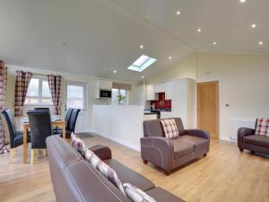 a living room with two couches and a kitchen at Cackle hill lakes in Biddenden