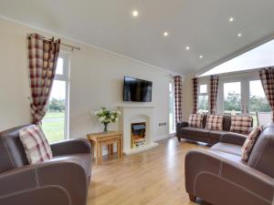 a living room with couches and a fireplace at Cackle hill lakes in Biddenden