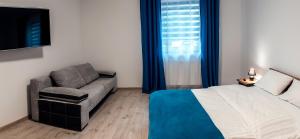 a bedroom with a bed and a couch and a window at Apartament w Bizancjum 8 PARKING FREE 24H in Kłodzko