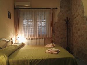 a bedroom with a green bed with towels on it at B&B Esperança in Frascineto
