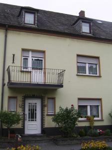 a large white house with a balcony on it at Ferienwohnung Bergblick in Trittenheim