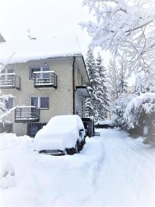 samochód pokryty śniegiem przed domem w obiekcie Willa Centrum w Zakopanem +19 zdjęć