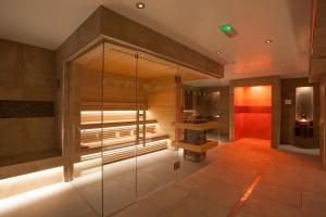 a bathroom with a glass shower with a bench at Netherwood Hotel & Spa in Grange Over Sands