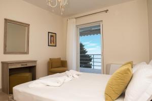a bedroom with a white bed and a window at Kiveri Luxurious Seaside Apartment in Kiveri