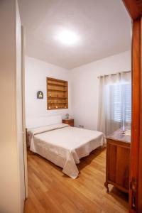 1 dormitorio con cama blanca y suelo de madera en La casa di Francesca, en Castelnuovo Berardenga