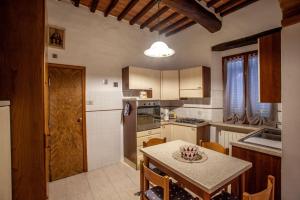 eine Küche mit einem Tisch und einer Arbeitsplatte in der Unterkunft La casa di Francesca in Castelnuovo Berardenga