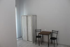 una mesa y sillas en una habitación con armario en Kvara's House, en Kutaisi