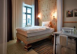 
a hotel room with a bed and a window at 25hours Hotel The Royal Bavarian in Munich
