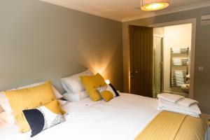 ein Schlafzimmer mit einem Bett mit gelben und weißen Kissen in der Unterkunft The Forge Bed & Breakfast in Auchterarder