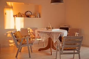 a dining room with a white table and chairs at Domek na Zwierzynieckim Rogu in Trygort