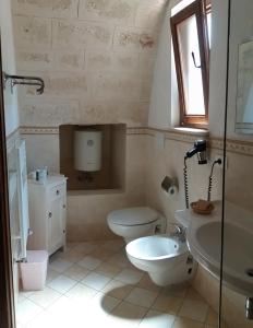 La salle de bains est pourvue de toilettes et d'un lavabo. dans l'établissement Masseria De Michele, à Montalbano