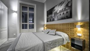 a bedroom with a bed and a painting on the wall at Suite del Ponte Normanno in Palermo