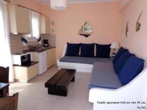 ein Wohnzimmer mit Couch und Küche in der Unterkunft Blue Harmony Apartments in Plaka