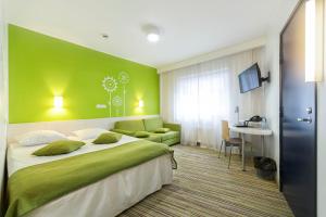 a bedroom with a large bed and a green wall at Tallink Express Hotel in Tallinn