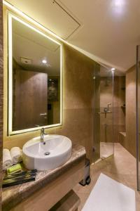 a bathroom with a sink and a shower at Hotel Orient Regency in Mumbai