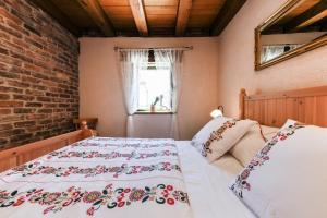 ein Schlafzimmer mit einem Bett und einer Ziegelwand in der Unterkunft Stone house BURA in Tribanj-Krušćica