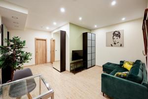 a living room with a green couch and a television at Plaza de Toros Apartamentos in Alicante