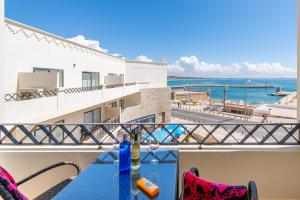 een balkon met een tafel en uitzicht op de oceaan bij Fábrica da Ribeira 70 by Destination Algarve in Lagos