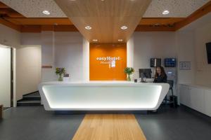 a woman sitting at a desk in an office at easyHotel Maastricht City Centre in Maastricht