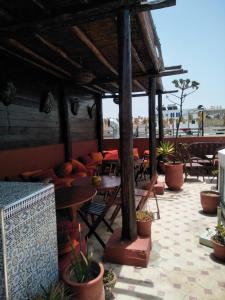an outdoor patio with tables and chairs and potted plants at Caverne d'Ali Baba in Essaouira
