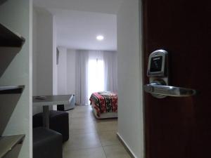 Una puerta que conduce a una habitación con dormitorio en Hotel Pinar del Lago en Villa Carlos Paz
