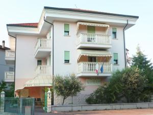 a white apartment building with balconies and trees at Nice Hotel in Marghera