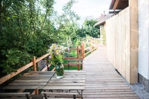 un jarrón de flores sentado en una mesa de madera con un banco en Nature nook, en Bled