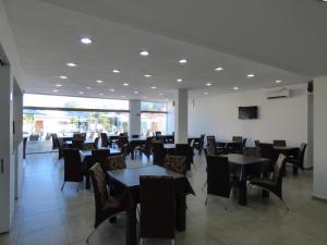 a dining room with tables and chairs in a building at Hotel Pinar del Lago in Villa Carlos Paz